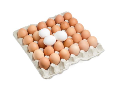 Thirty brown and speckled chicken eggs in the cardboard egg tray and three white eggs from above on a light background
