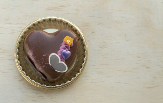 Fancy Heart shaped chocolate cake on a wooden table