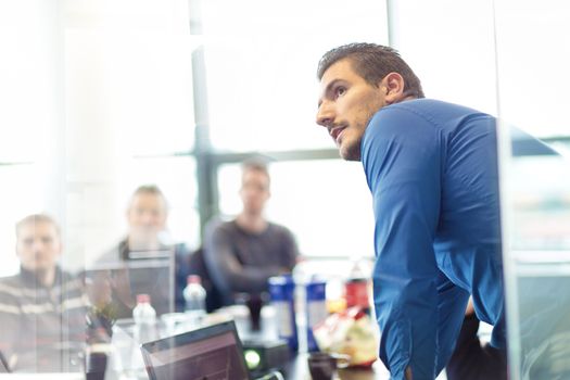 Businessman making a presentation at office. Business executive delivering a presentation to his colleagues during meeting or in-house business training, explaining business plans to his employees.
