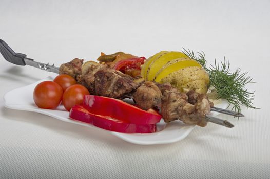 Kebabs grilled meat tomatoes and vegetables on white background 