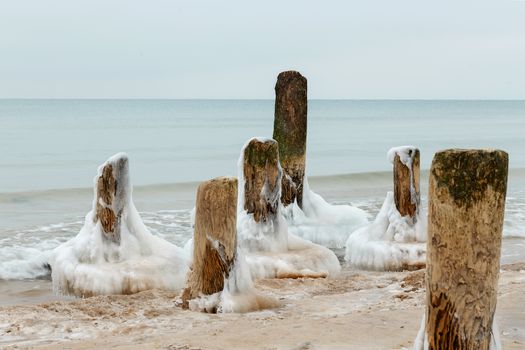 Ice on the breakwater in the form of skirts in the Baltic Sea