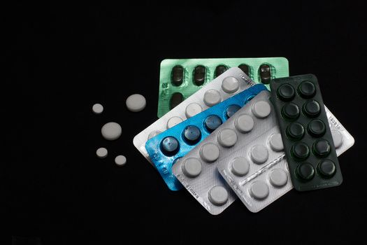 blue green white pills on black background