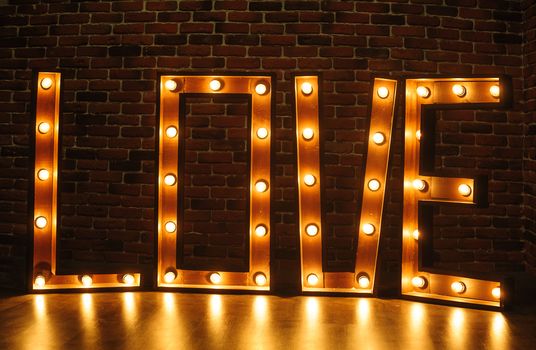 large wooden word love with lights in the studio