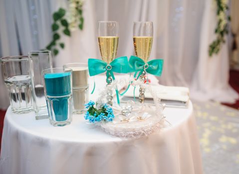 two glasses with champagne and other attributes for the wedding ceremony.