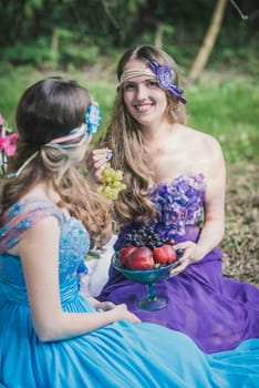 two adult sisters with fruit in the garden