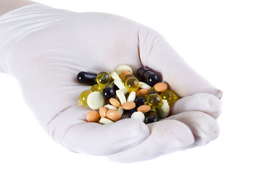 Pharmaceutical pills on a hand in latex glove on a white background