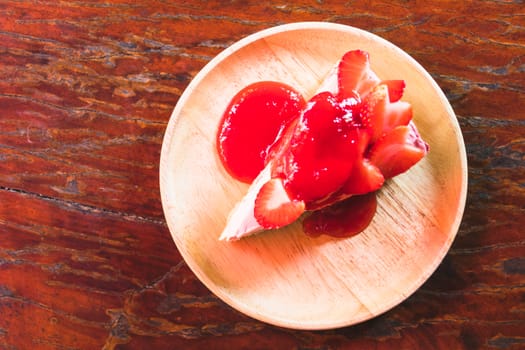 homemade cheesecake with strawberries on wooden dish