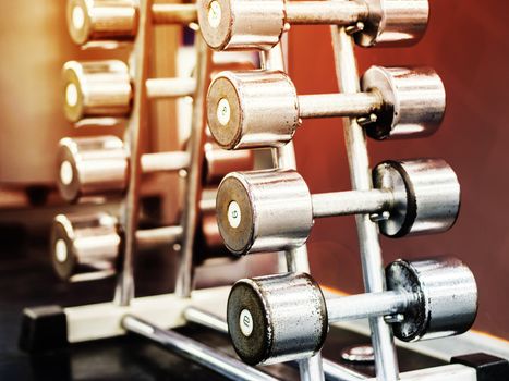Stand with dumbbells in gym with hign contrast and monochrome color tone