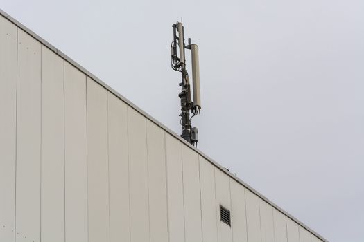 Antenna, telecommunications tower on a roof, wireless telecommunications concept.