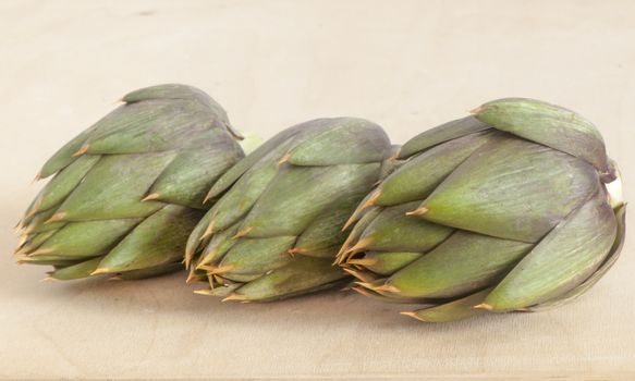 Italian raw artichokes on a wooden board