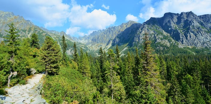 Panorama of the High Tatra mountains with tourist stone path. 