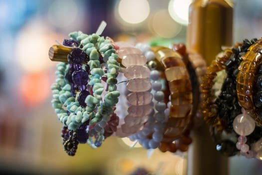 The bracelets hanging on a wooden stand.