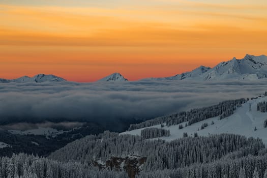 Mountains with a sunrise surrounded by cloudsin the Alps