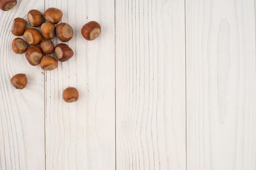 Hazelnuts on a old wooden table. Abstract background, empty template. Top view