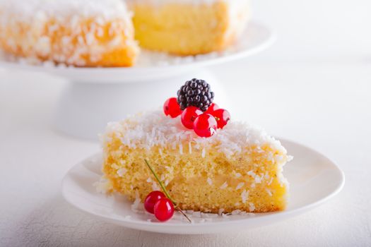 A piece of Homemade coconut cake on a white plate.