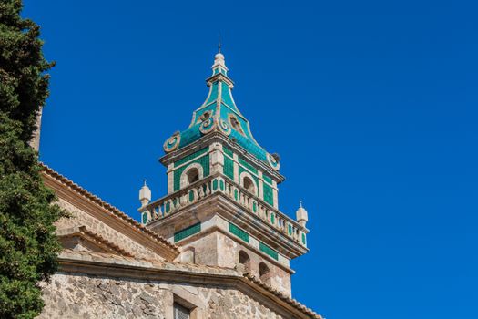 Beautiful view. Tower of the Monastery of Valldemossa in the Sierra de Tramuntana Mountains with park.