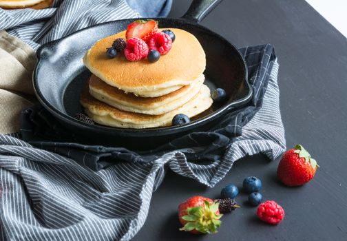 Selective focus Pancakes with blueberries  & raspberry on wood background