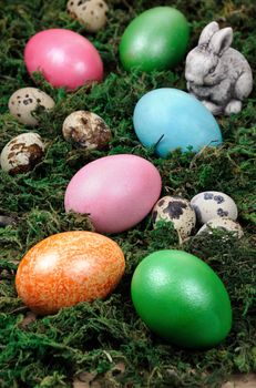 Easter colored eggs scattered on a green moss as an element of a holiday decoration ideas