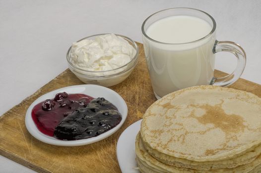 pancakes with jam and milk smeranoy on a wooden plank