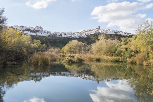 Panoramic of Arcos de la Frontera reflected in the river, white town built on a rock along Guadalete river, in the province of Cadiz, Spain