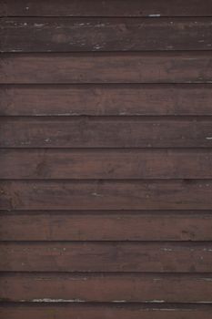 Horizontal running grungy brown stained painted planks and boards from a waterfront cottage.