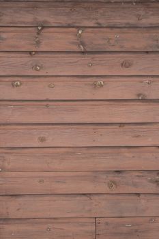 Horizontal running grungy brown stained painted planks and boards from a waterfront cottage.