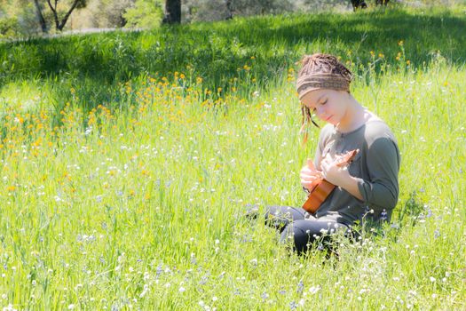 Cute Young Girl With Ukulele in Green Grassy Field