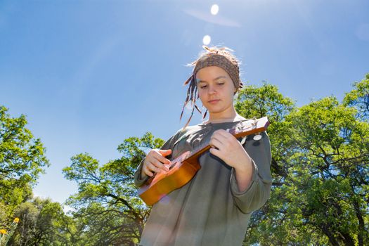Cute Young Girl With Ukulele Under Sunlight Sky