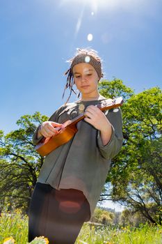 Cute Young Girl With Ukulele Under Sunlight Sky