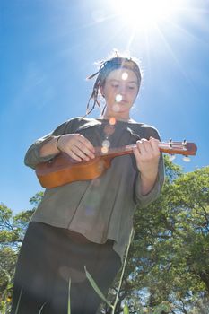 Cute Young Girl With Ukulele Under Sunlight Sky