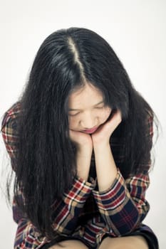 Chinese teenager sad with head in hands