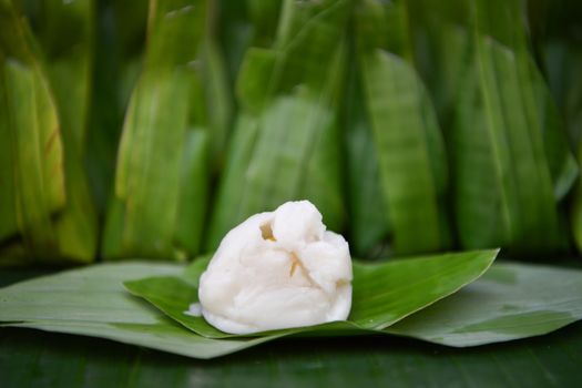 Steamed flour with coconut filling, flour in put grated coconut and wrapped in banana leaves steamed, Thai traditional dessert.