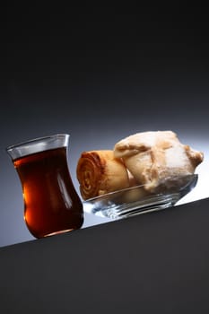 Cup of  oriental tea near pastry on nice dark background