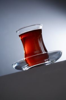 Cup of Turkish tea on saucer against nice dark background