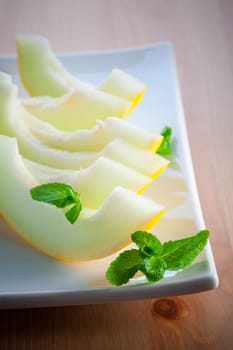 Fresh ripe honeydew melon slices on the plate