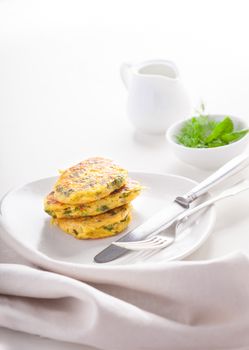 Healthy vegetarian zucchini fritters on a white surface