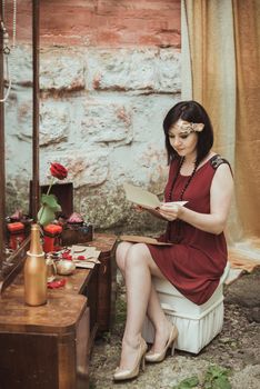 retro girl sitting at a dressing table and reading a letter