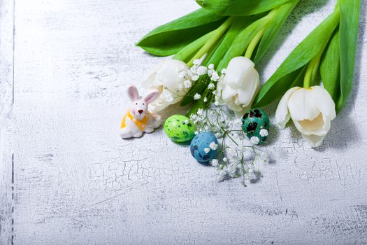 Bunny, eggs and white flowers. Easter symbols