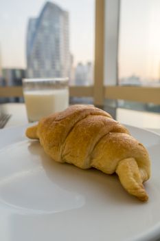 Breakfast with milk and fresh croissants, selective focus