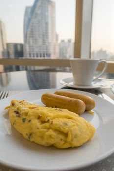 Breakfast with ommelette, sausage and glass of milk