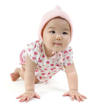 Portrait of full length Asian baby girl in pink clothes crawling on floor, isolated on white background.