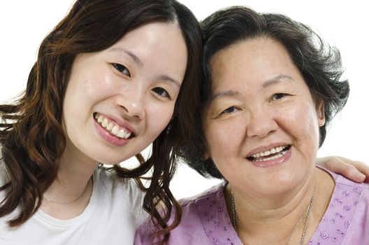 Close up portrait of Asian senior mother and adult daughter smiling and looking at camera, isolated on white background.