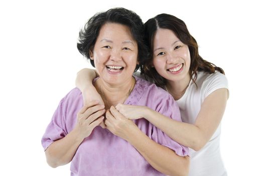 Portrait of Asian adult daughter hugging senior mother and smiling, isolated on white background.