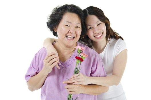 Celebrating mothers day. Portrait of Asian senior parent and adult offspring, carnation flower present from daughter, isolated on white background.