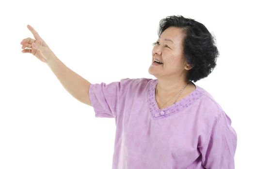 Portrait of Asian senior adult woman smiling and hand pointing at blank copy space, isolated on white background.