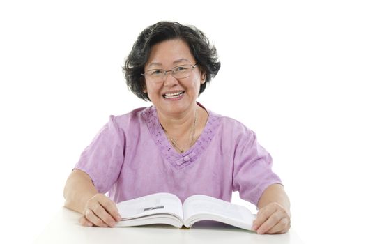Portrait of happy Asian senior adult woman reading book, isolated on white background.