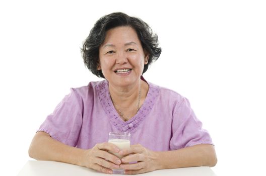 Portrait of happy Asian senior adult woman hand holding a glass soy milk, isolated on white background.