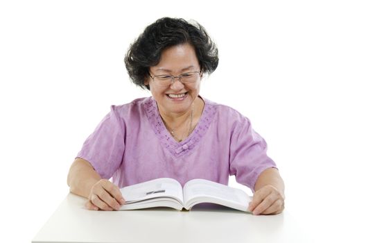 Portrait of wise Asian senior adult woman reading book, isolated on white background.