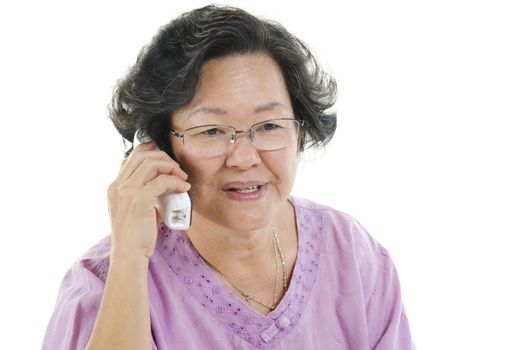 Portrait of 60s Asian senior adult woman calling on phone, isolated on white background.