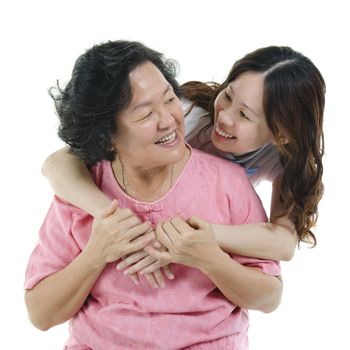 Portrait of Asian adult daughter embracing senior mother and smiling, isolated on white background.